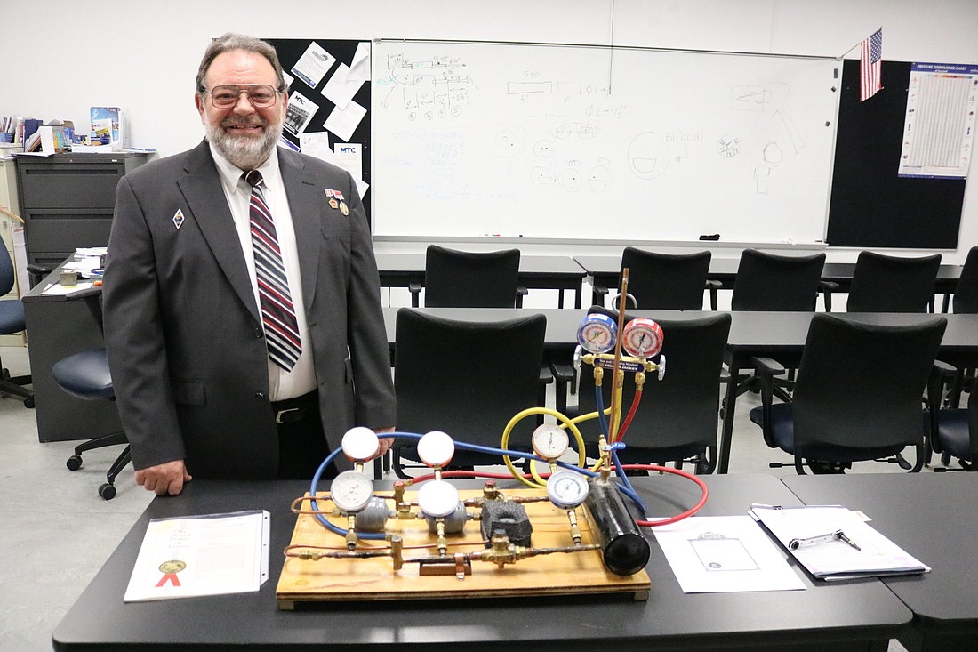 Michael Afanasiev, an instructor at Manatee Technical College, with his invention called the Air Conditioner Educational Demonstration System and Method of Operation.