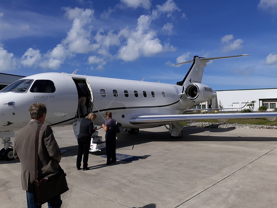 Media members board Embraer&#39;s Phenom Legacy 500 at Naples airport for a demonstration of a private business flight. Andrew Warfield photo