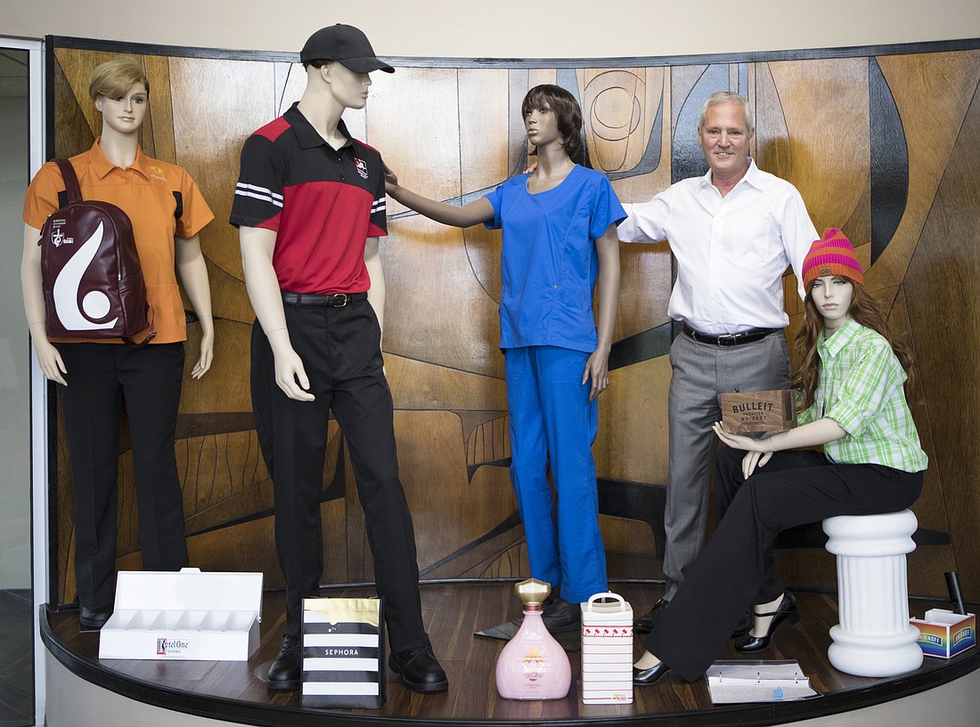File. Superior Group of Companies CEO Michael Benstock poses with mannequins clad in some of the firm&#39;s clothing products.