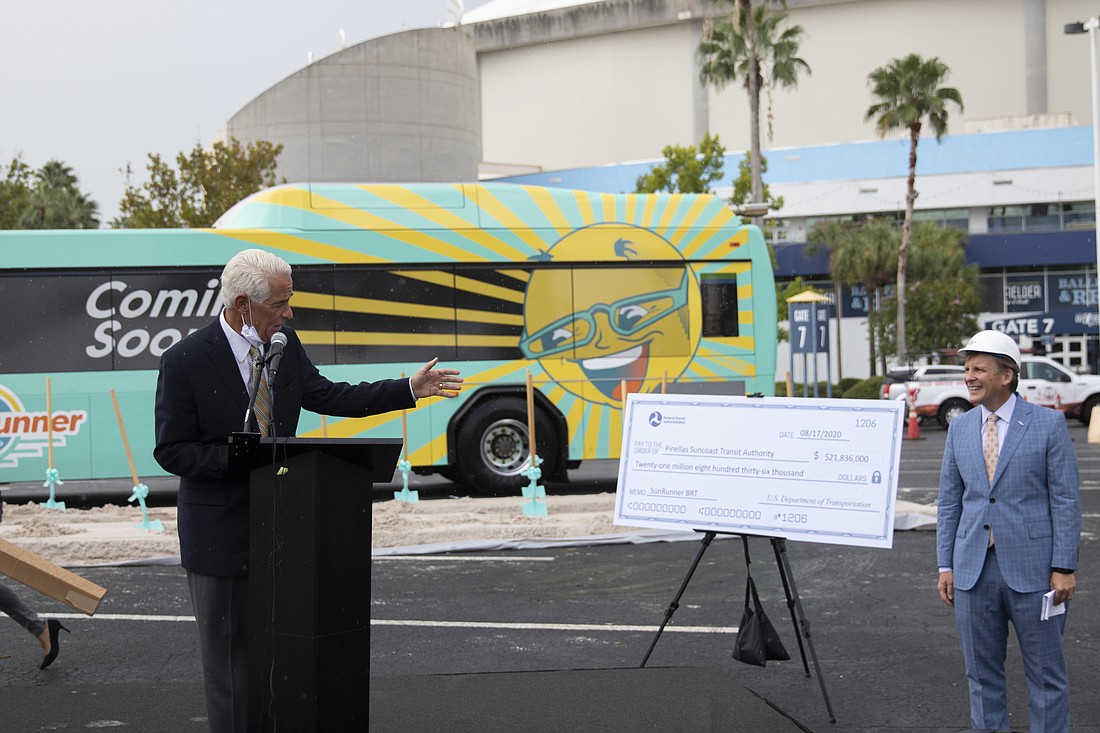 Courtesy. U.S. Rep Charlie Crist, D-St. Petersburg, hands over a $28.1 million check to the Pinellas Suncoast Transit Authority for the new SunRunner bus service.
