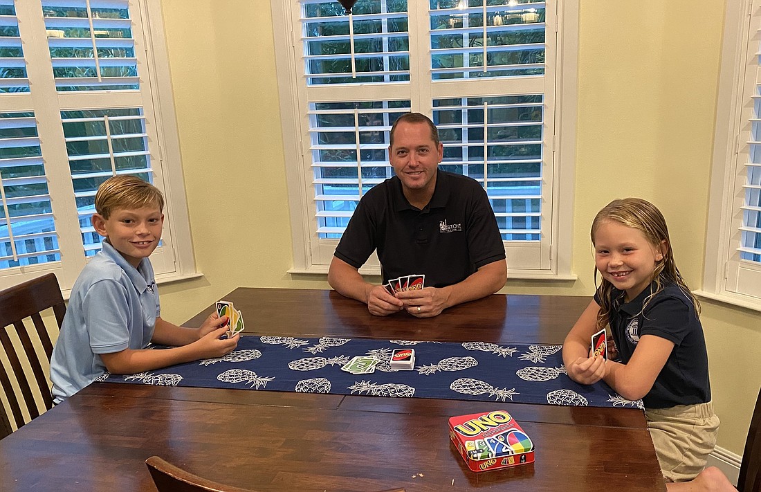 Courtesy. Ryan Lodge plays uno with his family.