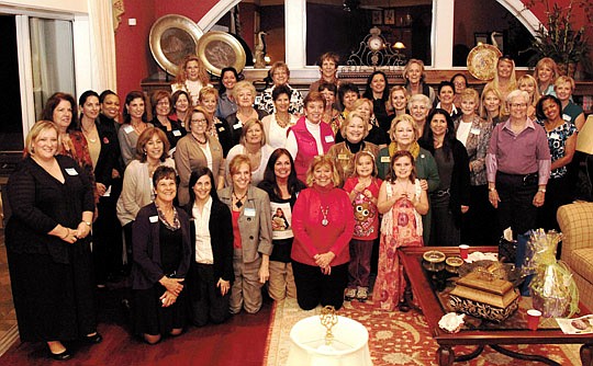 The Womanade group of Realtors and builders gathered recently to start their 11th year of charitable work. The meeting was held in the Palencia home of Pud English (kneeling, center, in red blouse.)