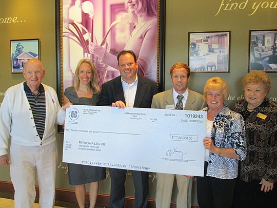 The check and William LeSeur;  Richmond American executives Ashley Davis, Doug Moran and Andy Kern; Patricia LeSeur; and Mary Ann Crouch, Watson Realty.