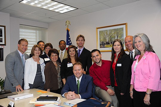 Rep. Travis Cummings (seated) with NEFAR members Ryan Huckstep, Karen Stern, John Elian, Millie Kanyar, Angela Tharp, Charles McInnis, Diana Galavis, Mick Dolan, Taulant Marra, Michele Magueur, Marc Jernigan and Diane Cook.