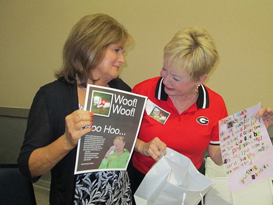 Rita Williams of Merchandising Plus and Lumley look over the "ransom note" and flyer.