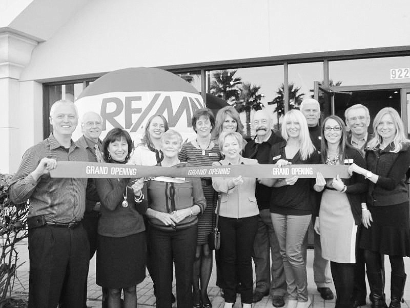 Broker/owner John Glover (left) did the ribbon-cutting honors. His staff  and guests included (from left) Bill McCombes, Tami Glover, Ashley Ridlen, Maggie Haynes, Debby Leahy, Angie Clausen, Sue Molly, Ed Mercel, Melanie Escalante, Al Grant, Jenni Ba...