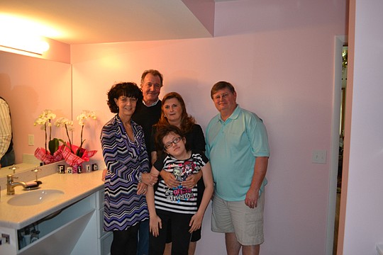 Barbara Antill (center) gives her granddaughter Dawn added support as they see Dawn's newly remodeled bathroom for the first time. From left, Cheryl Martin Connor of Schulte Design Associates, and Tom Trout III and Chuck Hosea of BeeTree Homes, were p...
