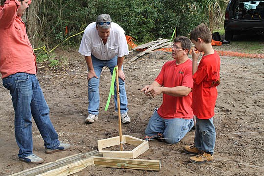 Benjamin Morrison, Nassau builder Clayton Buchanan, Bill Mooney and Cody Mooney place the first pieces of a pentagonal-shaped deck resembling Fort Clinch. Members of the Nassau Builders Council helped local nonprofit 8 Flags Playscapes in March to bui...