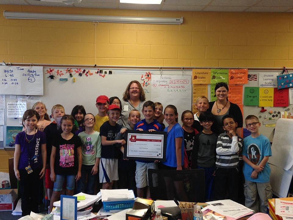Davidson Cares representative Peyton Davidson (back row, right) presents a $1,000 grant to Principal AmandaÂ Riedl (back row, center) at Mill Creek Elementary.