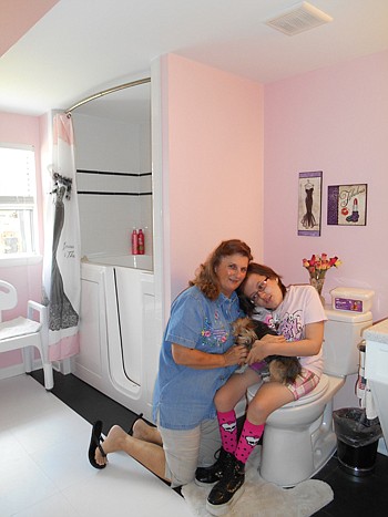 Dawn Boles and her grandmother, Barbara Antill, share a hug in the bathroom that has given Dawn more freedom and independence. The walk-in bathtub allows Dawn to soak in warm water to relieve her chronic pain.