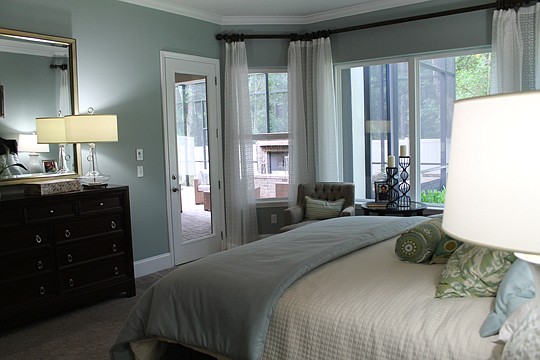 A view of the oversized lanai from the master bedroom in David Weekley Homes' Sunnyside model. The lanai includes a courtyard, outdoor kitchen and fireplace.