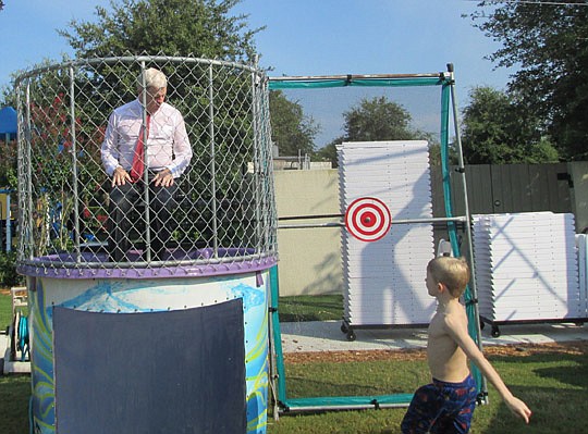 John Morris, division president for David Weekley Homes, discovered it takes just a toss of a ball to go from perfectly dry (above) to soaked (below). Morris was a victim in the company's dunking booth at the Sales and Marketing Council family picnic ...