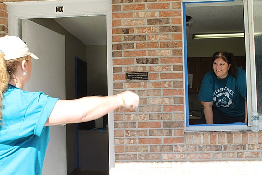 Nanci Soriano, administrator at Exit Real Estate Gallery, talks with another volunteer at Daniel's Project Prepare apartments.