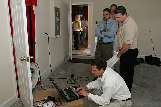 David Reed of JEA demonstrated a blower test for guests in the energy-efficient Green Built home.