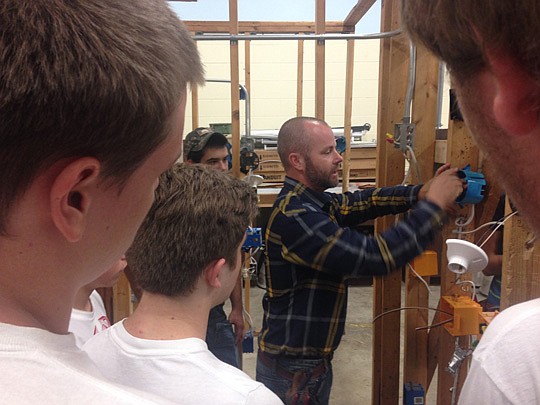 Apprentice graduate and business owner David Harp demonstrates his expertise to electrical students at Middleburg High School.