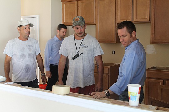 Cameron Gaskill, right, specifies granite countertops and other upgrades for this renovation at OakLeaf Plantation. A rehab investor and the owner of Suncoast Renovations, Gaskill picked up this foreclosure for $159,000. With him are crew members John...