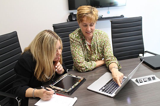 Michele Vescovacci, a social media and marketing consultant, and Lisa Barton, broker for Berkshire Hathaway HomeServices Florida Network Realty in Ponte Vedra, plan a social media campaign for the real estate office.