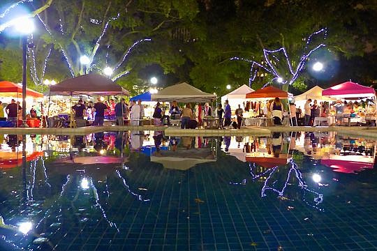 Artists' tents are reflected in the pool in Hemming Plaza during First Wednesday Art Walk. The theme for the night was "Art is for Lovers."
