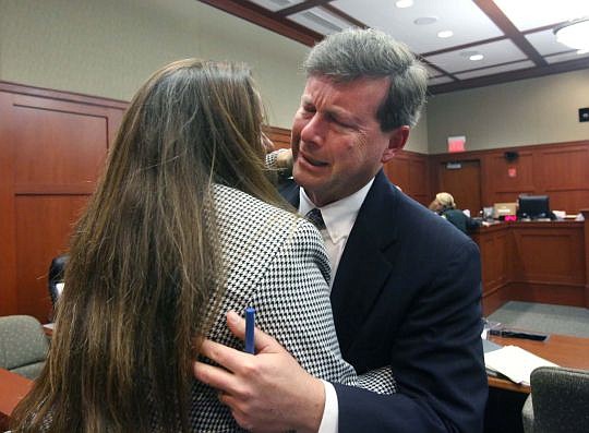 Jacksonville attorney Kelly Mathis hugs his wife, Donna, after a judge sentenced him to six years.