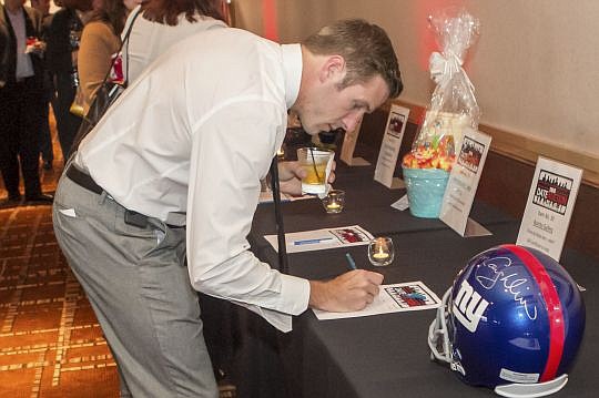 Travis Collins bids on one of the items available for the silent auction during last week's Date Auction to benefit Jacksonville Area Legal Aid. The event raised $13,000.