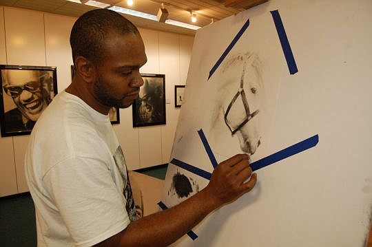 Adrian Pickett Jr. working in his studio and gallery inside the Jacksonville Landing.