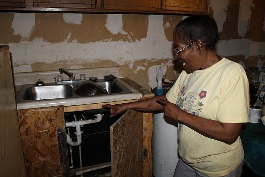 Bessie Walker's family members did their best to patch things as her New Town house wore down. But they didn't have professional expertise. Here, the kitchen sink is too high, and the plumbing underneath leaks. Walker's home is one of 25 in her neighb...