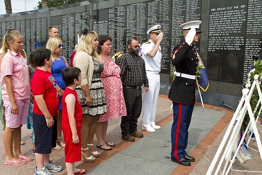 The family of Johnny Oliver places a wreath at the Veterans Memorial Wall during a ceremony Monday.