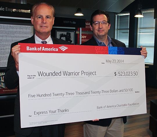 Greg Smith (left), Northeast Florida market president for Bank of America, presents Al Giordano, chief operating officer and co-founder of Wounded Warrior Project, with a $523,000 donation from the bank's Express Your Thanks social media campaign. Ban...
