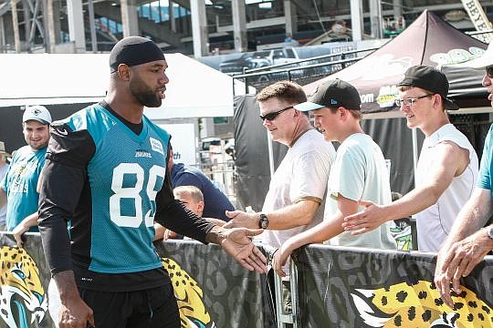Tight end Marcedes Lewis greets fans on his way into camp.