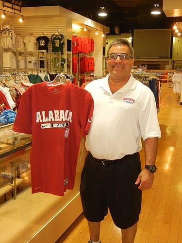 Sales associate Mike Akabekjan unpacks Sports Mania goods early Saturday afternoon at Regency Square Mall.