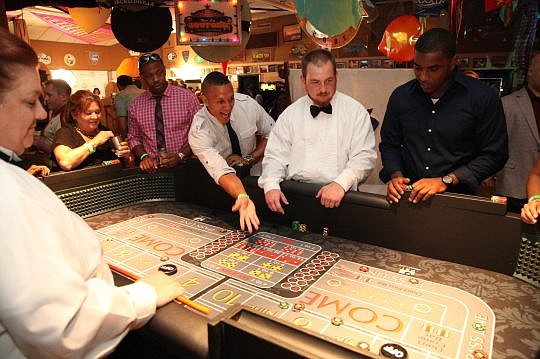 Jacksonville native and Denver Broncos cornerback Tony Carter rolls the dice at the Casino Night fundraiser for the Leon Washington Foundation.