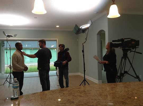 The crew from "House Hunters" puts a microphone on Colin Adams (left) during the January filming of an episode for the show. Adams and his wife, Chandra, looked at three houses, ultimately buying a house off Julington Creek Road. They were on the epis...