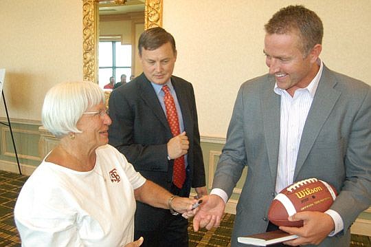 As Gator Bowl Sports Chief Operating Officer Alan Verlander (center) was trying to get him out of the Hyatt and to the airport, ESPN's Kirk Herbstreit paused to autograph a football for a fan.