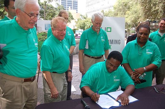 Mayor Alvin Brown signed legislation to transfer management of the city park to Friends of Hemming Park, witnessed by, from left, City Council members Bill Gulliford and Don Redman, Friends Executive Director Vince Cavin and president Wayne Wood and c...