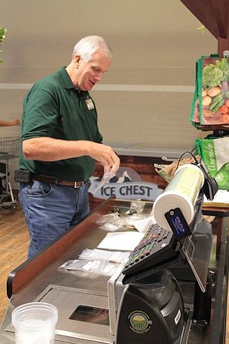 A Fresh Market worker separates store keys into plastic bags for employees. The new store opens Wednesday.
