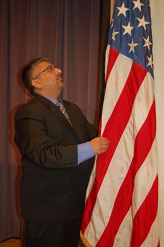 Mitesh Sangani, manager of the Main Library Conference Center, made sure the American flag on the stage in the Hicks Auditorium was properly furled for Friday's naturalization ceremony. He has prepared the stage many times before people became the new...