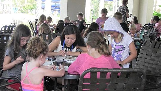 Aisulu Ispayeva works with children during craft week at summer camp in Nocatee. Ispayeva came from Kazakhstan to teach at the camp.