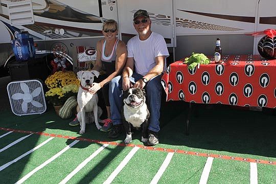 Sharon and Todd Love, with their dogs, Daisy and Mayhem, take a break from setting up their camp.