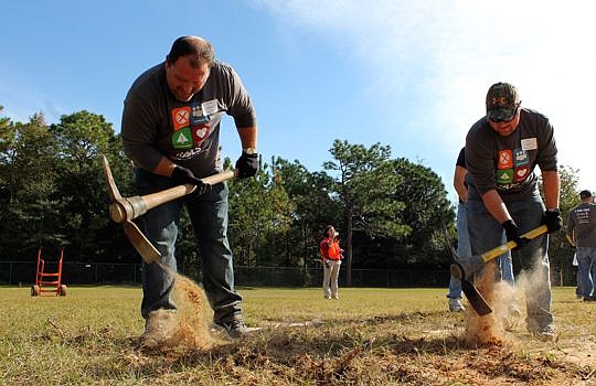 CSX management trainees Wendell Anderson, a Roadmaster from Jacksonville, and Jon Freese, Capital Projects System Production Engineer from Ortonville, Mich., dig holes to plant trees at Chimney Lakes Elementary School. Volunteers planted more than 70 ...