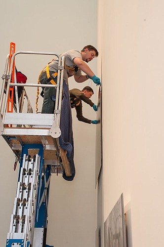 Installers work to hang the work of Angela Strassheim at Museum of Contemporary Art.