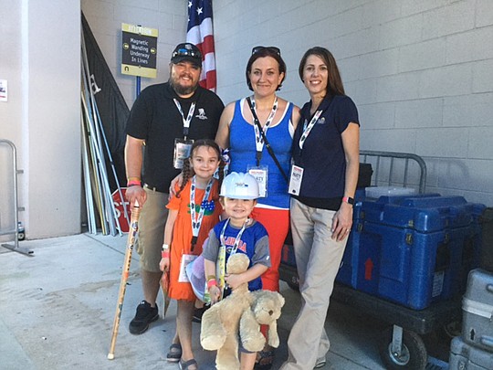 Tara Jinks, right, Pulte director of sales for Jacksonville, congratulates Staff Sgt. David R. Veros Jr., his wife, Carolyn, and children, Natalie and Trip. The family was surprised with a new home thanks to Pulte and FINALLY HOME.
