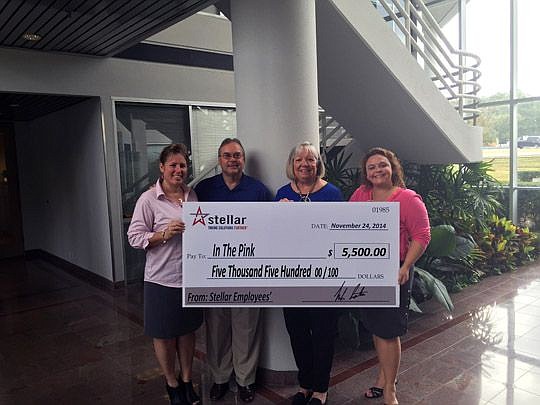 In the Pink's Jeri Millard, second from right, and Stellar employees Sandra Sweikata, Bob Owens and Kimberly Stanton with the design and engineering firm's donation to the nonprofit.
