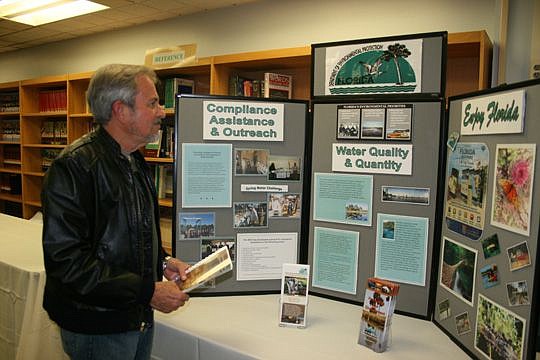 Richard Skule of the Southside reviews the Florida Department of Environmental Protection's exhibit at Wednesday's Eagle LNG Partners open house.