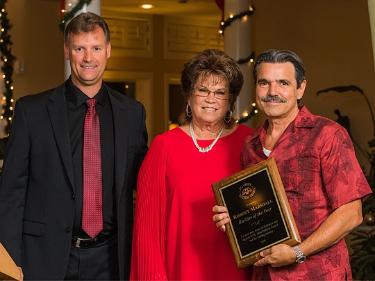 Jerry Dean, St. Johns Builders Council 2015 chairman, and Leona Brown, SJBC director, present  the builder of the year award to Robert Marshall of World Island Builders.