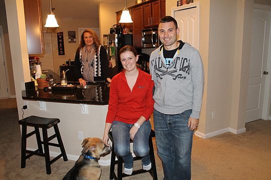 Military couple Anna and Nate Lucas with their dog, Max, had a month to find a new home when Nate was transferred to Kings Bay Naval Station. Their Realtor, Stephanie Saylor (background), said compressed timelines are one reason agents have to work ha...