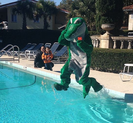 Lakeside Junior High School Principal John Green, dressed in the school's gator mascot costume, leaps into Club Continental's unheated swimming pool to celebrate his students' willingness to give back to the community. The students raised $5,000 to he...
