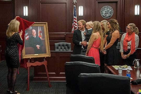 Retired Circuit Judge Brad Stetson's family members get their first look at his portrait as it is unveiled by his wife, Kathy, during a ceremony honoring her husband. Stetson decided not to seek re-election last year after serving as a judge since 1991.