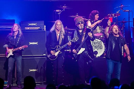 Lynyrd Skynyrd's lead singer Johnny Van Zant, right, lifts a toast to the crowd Thursday night at the Florida Theatre during "I Ain't The One." Band members from left are Mark Matejka, guitar; Rickey Medlocke, guitar; Johnny Colt, bass; and Michael Ca...
