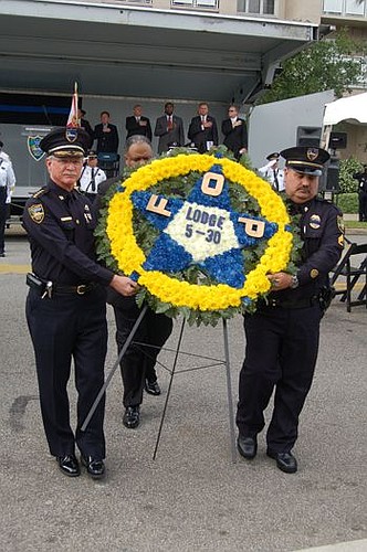 Jacksonville Sheriff John Rutherford, left, and Sgt. Steve Amos, president of Fraternal Order of Police Lodge 5-30, retired the wreath Wednesday at the conclusion of the annual Police Memorial Day observance.