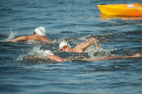An avid swimmer, Alabiso, (right) swims in the St. Johns River as part of the Up The River Downtown event. On his arms, he has names of people that he swims for during the event.